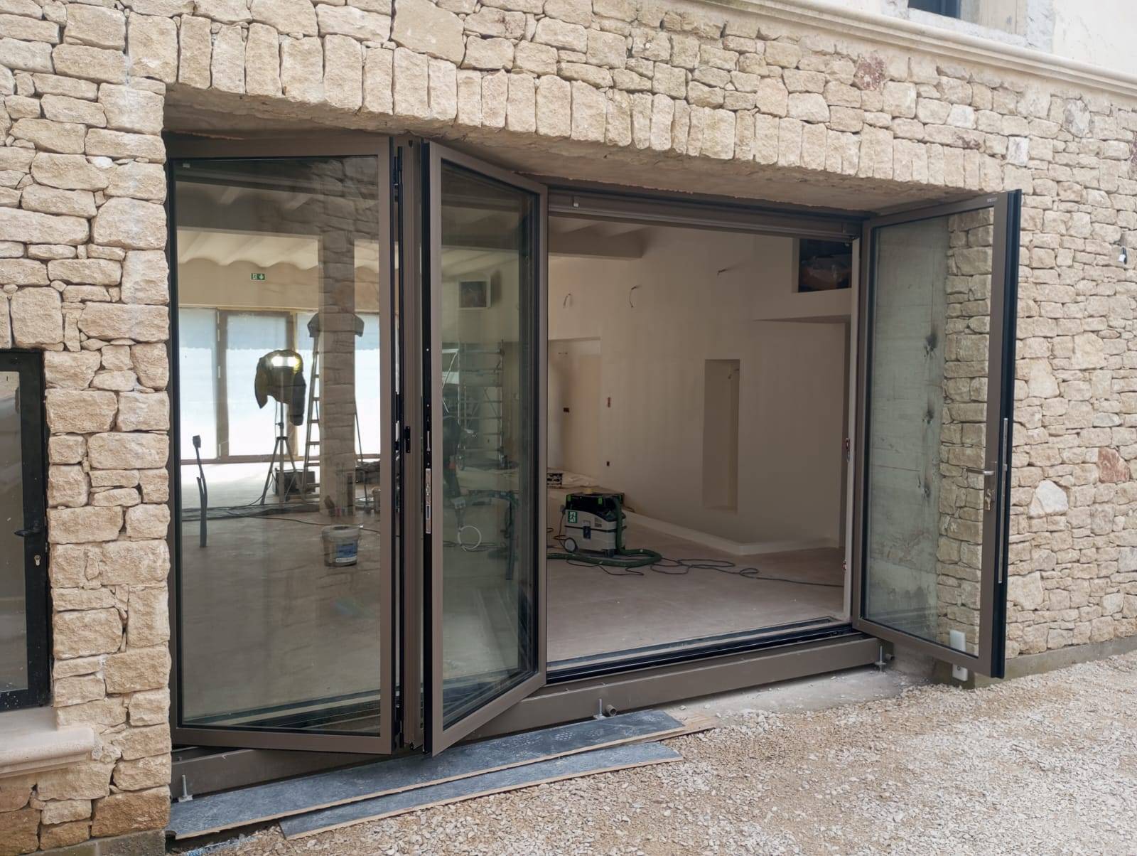 Pose d’une baie vitrée coulissante en accordéon en aluminium sur mesure à Cabrières d’Avignon avec porte intégrée et ouverture extérieure