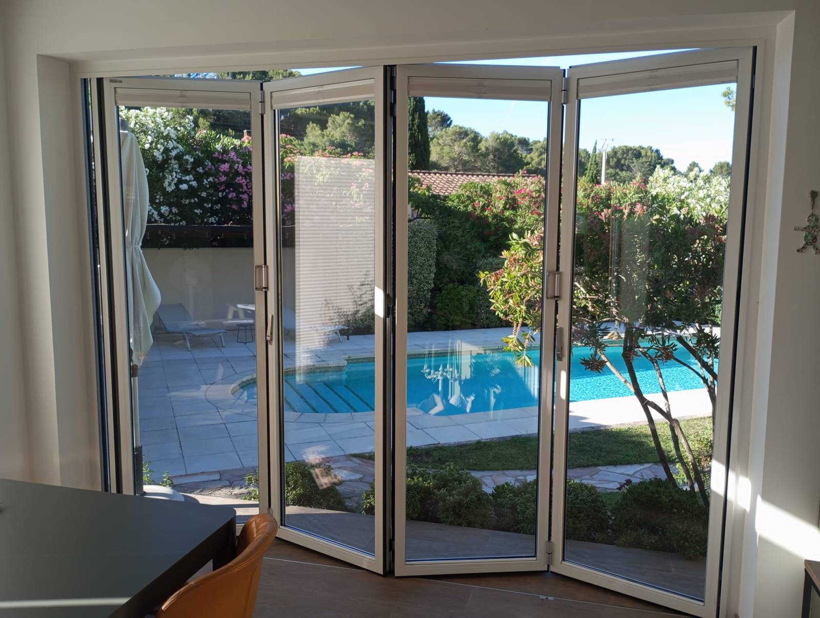 Pose d’une baie vitrée coulissante accordéon en aluminium 4 vantaux sur mesure à Beaumes de Venise avec stores plissés intérieurs et ouverture extérieure