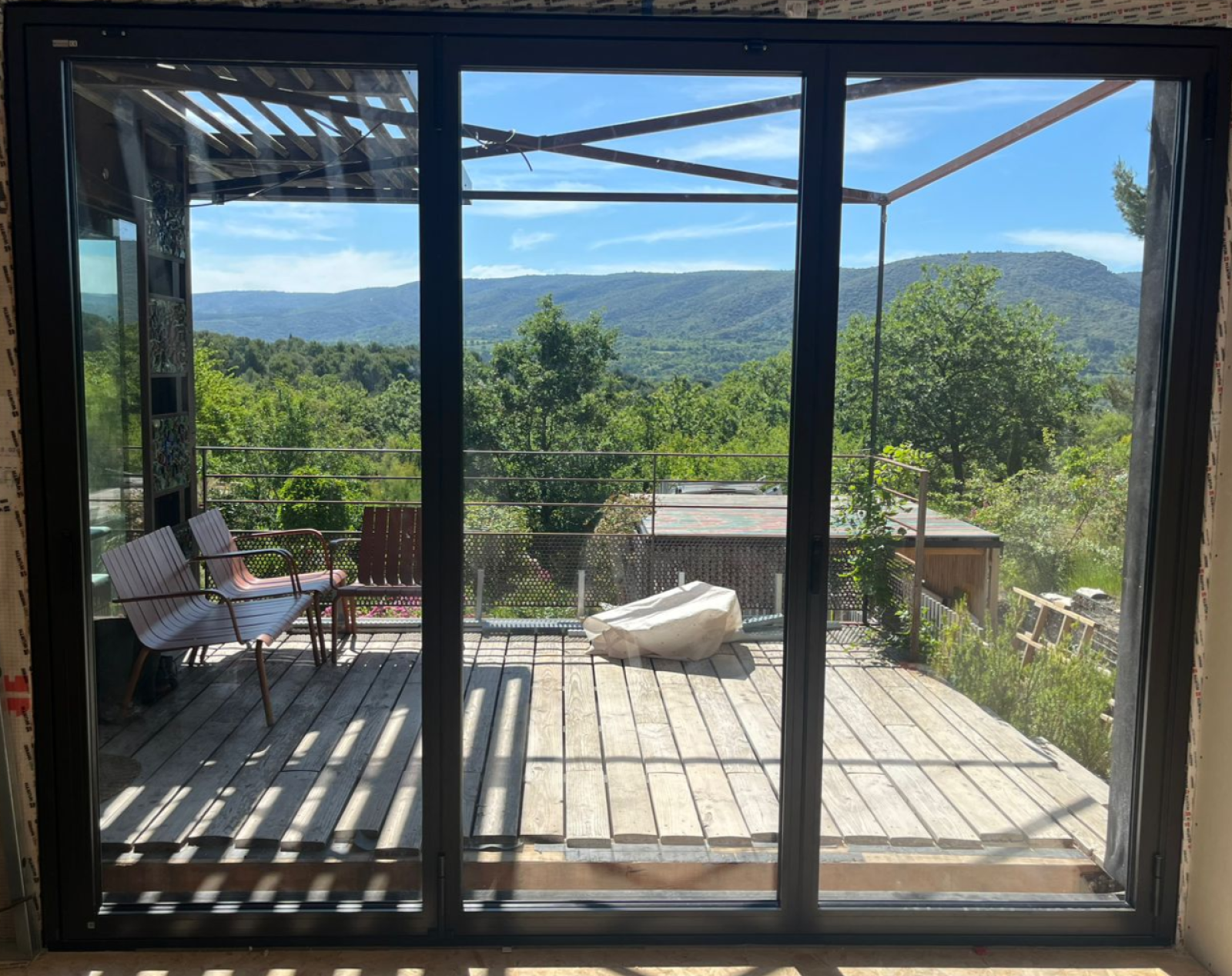 pose d’une baie coulissante accordéon en aluminium sur Malemort du Comtat, avec double vitrage verre feuilleté et rail encastré