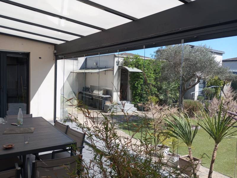 Coulissant pivotant tout en verre de 7 m installé à Sauveterre pour une terrasse