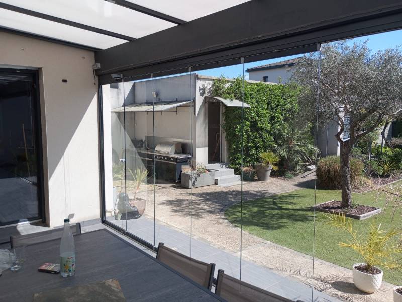 Pose d’un coulissant pivotant tout vitré de 7 m pour fermer une terrasse à Sauveterre