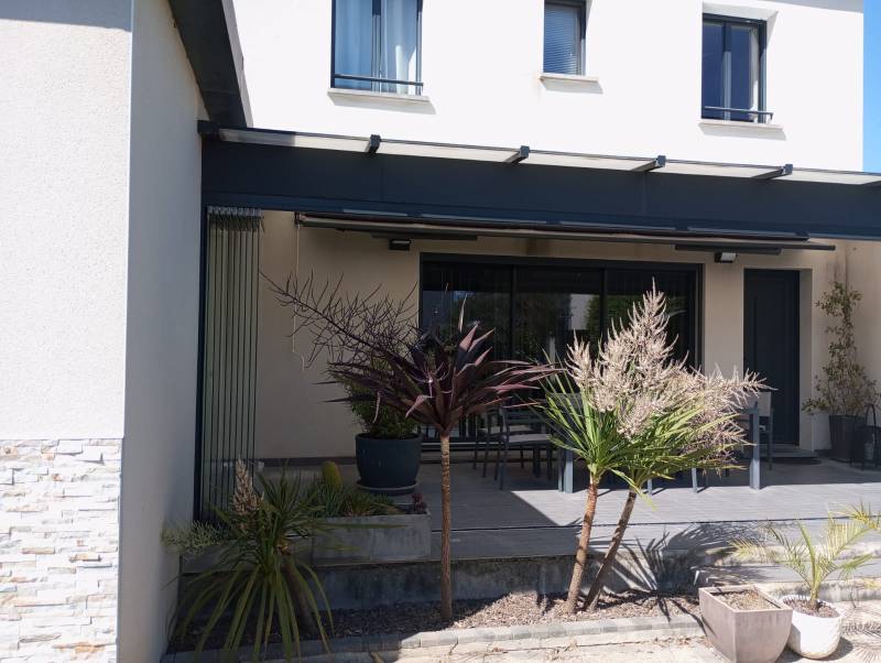 Terrasse fermée à Sauveterre grâce à un coulissant pivotant tout vitré de 7 mètres